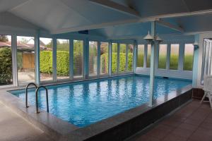 a swimming pool in a house with windows at Haus Windrose App. 3 in Butjadingen