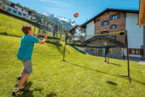 deux jeunes garçons jouant au volley-ball dans l'établissement B&B AZapartments Lunic, à Grächen