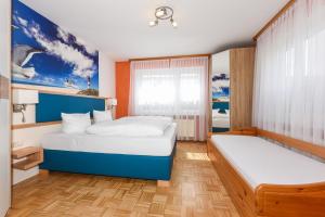 a bedroom with two beds and a window at Haus am Kajedeich mit Frühstücksoption in Bensersiel