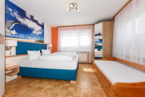 1 Schlafzimmer mit 2 Betten und einem Fenster in der Unterkunft Haus am Kajedeich in Bensersiel