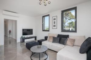 een woonkamer met een witte bank en een tv bij Luxury Suite Lady Of The Rock in Dubrovnik