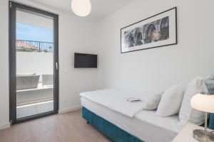 een witte woonkamer met een bank en een tv bij Luxury Suite Lady Of The Rock in Dubrovnik