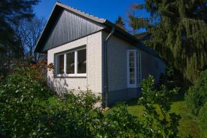 uma pequena casa com um telhado de gambrel em Ferienhaus Schils Zur alten Heidegärtnerei em Bispingen