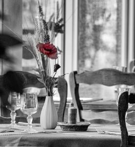 Logis Hotel du Lac في Neuvic: طاولة مع إناء من الزهور على طاولة
