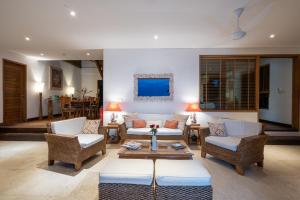 a living room with couches and chairs and a table at Villa Nusa in Nusa Lembongan