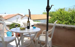 a table with a bottle of wine and chairs on a balcony at house in the village near the sea in Maleme