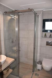 a bathroom with a shower with a toilet and a sink at Olivella Villas by Vatos in Keri
