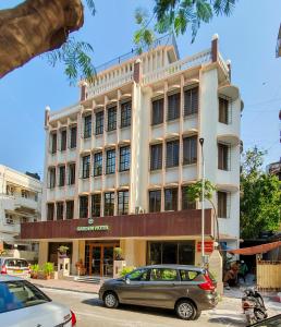 un edificio con un coche aparcado delante de él en Garden Hotel en Bombay