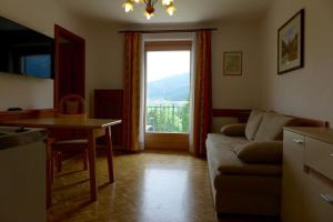 a living room with a couch and a table and a window at Haus Salzburgerland in Mauterndorf