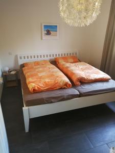 dos camas sentadas una al lado de la otra en un dormitorio en Haus Boddensonne, en Fuhlendorf