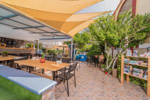 een patio met tafels, stoelen en bomen bij Oscar Villa & Studios in Alykes