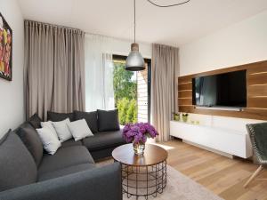 un soggiorno con divano e TV di One Apartments a Pärnu