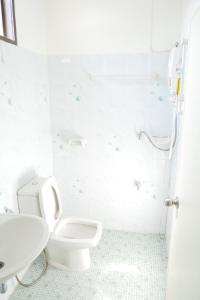 Fang villa mansion في فانغ: حمام ابيض مع مرحاض ومغسلة