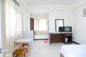 a room with a bed and a table and a refrigerator at Fang villa mansion in Fang