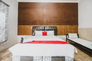 a bedroom with a large bed and two benches at RedDoorz near Millennium ICT Center Medan in Medan