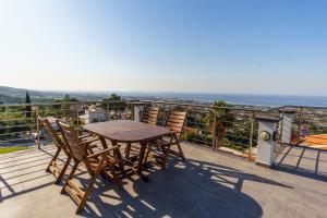 uma mesa e cadeiras numa varanda com o oceano em Bellapais Apartments em Kyrenia