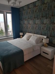 um quarto com uma grande cama branca e uma janela em Luksusowe Apartamenty na Toruńskiej em Kwidzyn