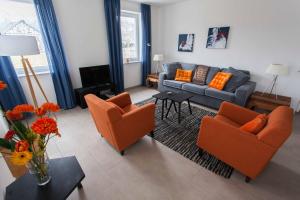 a living room with orange chairs and a couch at Das gelbe Haus 1 in Winterberg