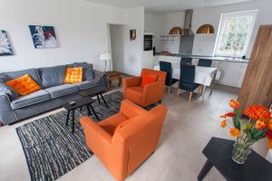 a living room with orange chairs and a couch at Das gelbe Haus 1 in Winterberg