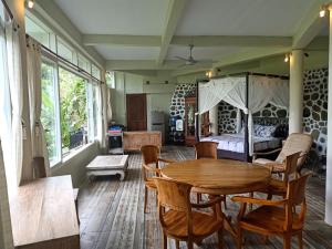 a living room with a wooden table and a bed at Tirta Asri Ubud Villa in Ubud
