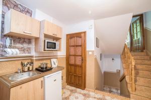 een keuken met een spoelbak en een magnetron bij Pokoje Gościnne u Bronka in Ciche Małe
