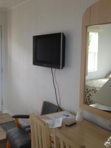 a room with a table and a television on the wall at Hôtel Motel du Rocher in Rivière-la-Madeleine +23 photos
