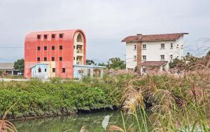 a group of buildings next to a river at Remis villa in Suao