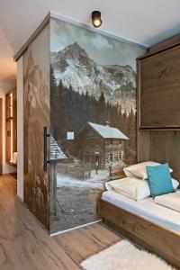 ein Schlafzimmer mit einem Wandbild einer Blockhütte in der Unterkunft Hotel Stern in Ehrwald