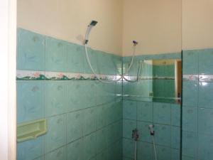a bathroom with a shower with blue tiles at Hotel Musafir Inn in Padang