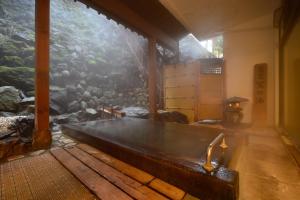 a large aquarium in a room with a bench at Osakaya Ryokan in Kusatsu