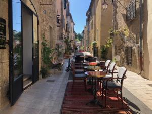 an alley with tables and chairs on a street at Demeure d'hôtes Le Rocher in Valbonne
