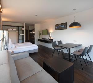 Sala de estar con sofá, cama y mesa en Hotel & Appartements Oberhofer, en Telfes im Stubai