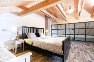 a bedroom with a large bed and a wooden ceiling at Apartmány MALIK in Dolní Dunajovice