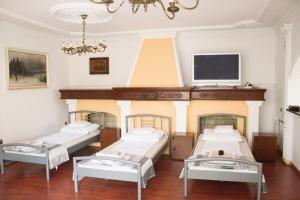 a hospital room with three beds and a fireplace at Magic Garden Hostel in Kalisz