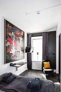 斯德哥爾摩的住宿－Eight Rooms，一间卧室配有一张床、一把椅子和一幅画