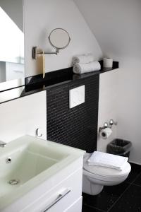 ein Badezimmer mit einem weißen Waschbecken und einer Toilette in der Unterkunft Hotel Stern in Düsseldorf + 37 Fotos