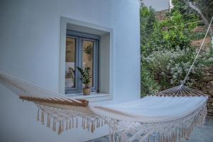 a hammock on the side of a house at Small Paradise in Andros