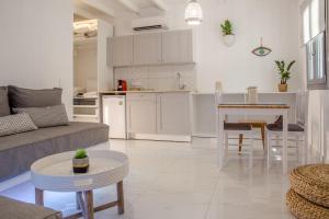 a living room and kitchen with a couch and a table at Small Paradise in Andros