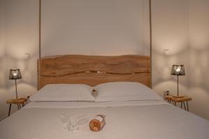 a bed with a wooden headboard with a shoe on it at Small Paradise in Andros