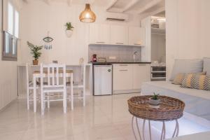 cocina y sala de estar con mesa y sofá en Small Paradise, en Ándros