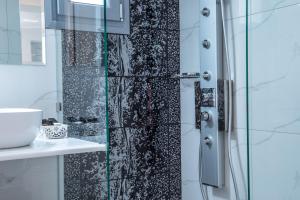 a shower with a black and white shower curtain at Small Paradise in Andros +35 photos
