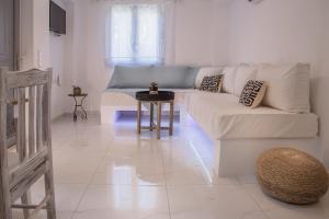Sala de estar blanca con sofá y mesa en Small Paradise, en Ándros