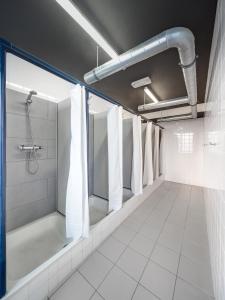 uma casa de banho com uma cabina de duche ao nível do chão e uma cabina de duche ao nível do chão em Generator Berlin Prenzlauer Berg em Berlim