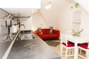 uma cozinha e sala de estar com um sofá vermelho em B&B Teate em Chieti