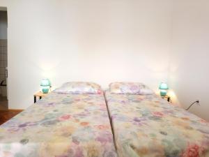 Charming Hill Apartment في أوباتيا: سريرين يجلسون بجانب بعض في غرفة النوم