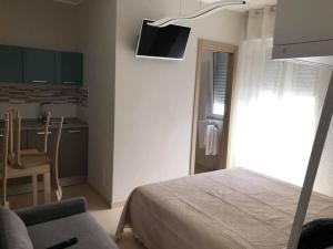 a bedroom with a bed and a table and a kitchen at Bed&Breakfast Luna in San Salvo