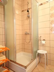 eine Dusche mit einer Glastür und einem Stuhl im Bad in der Unterkunft Charming Hill Apartment in Opatija
