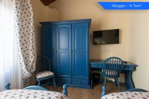 einen blauen Schrank mit 2 Stühlen und einem Schreibtisch in der Unterkunft B&B Loreto in SantʼAngelo di Brolo