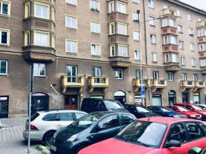 kilka samochodów zaparkowanych przed budynkiem w obiekcie Apartment Poruba STREET VIEW w Ostravie