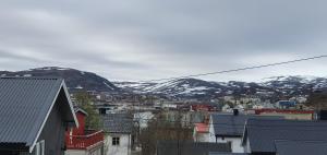 a view of a city with snow covered mountains at fjordRo in Båtsfjord +8 photos